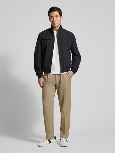 Männermodel trägt Jacke mit Stehkragen Modell 'POTOSI' von Peuterey, schwarz, glatte Textur, Regular Fit, Ganzkörperansicht von vorne.