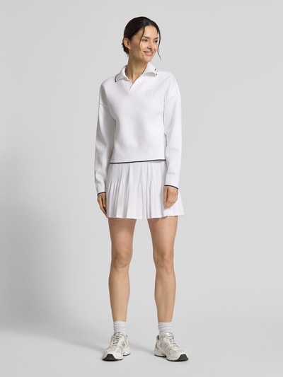 Frauenmodel trägt Regular Fit Sweatshirt mit Kontraststreifen von Lacoste Sport in Unifarbe, Polokragen, V-Ausschnitt, Ganzkörperansicht von vorne