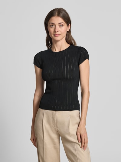 Frauenmodel trägt T-Shirt in Pointelle-Optik mit Rundhalsausschnitt von Guess, Schwarz, körpernaher Schnitt, Viskose-Mix, Ganzkörperansicht von vorne.