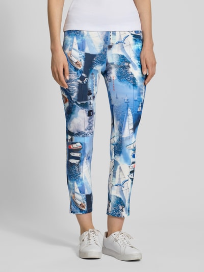 Frauenmodel trägt Slim Fit Caprihose mit elastischem Bund von Marc Cain, farbenfroher Allover-Look, Material-Mix mit Stretch-Anteil, Nahaufnahme Oberkörper.