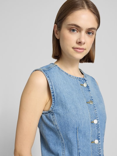 Frauenmodel trägt Regular Fit Jeansweste aus reiner Baumwolle Modell 'AYA' von Only in Denim-Optik mit V-Ausschnitt und Knopfleiste, Nahaufnahme Oberkörper.