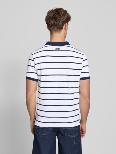 Männermodel trägt Slim Fit Poloshirt mit Label-Stitching und Knopfleiste von Superdry aus Reine Baumwolle, Rückenlänge 70 cm, Ganzkörperansicht Rückansicht.