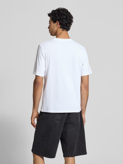 Männermodel trägt T-Shirt mit Statement-Print Modell 'RHYERES' von Jack & Jones aus gewachster Baumwolle, Regular Fit, Rückansicht Ganzkörperansicht.
