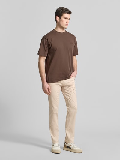 Męskimodel nosi spodnie z wpuszczanymi kieszeniami model 'Chuck' od Brax, mieszanka bawełny i lyocellu, krój slim fit, szerokość w rozmiarze 32/32: 43 cm, długość wewnętrzna nogawki w rozmiarze 32/32: 81 cm, jasny beż, gładka struktura, pełny widok z przodu.