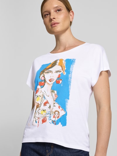 Frauenmodel trägt Relaxed Fit T-Shirt mit Motiv-Print von Oui aus Baumwoll-Modal-Mix, weiß mit buntem Print, Rundhalsausschnitt, Nahaufnahme Oberkörper.