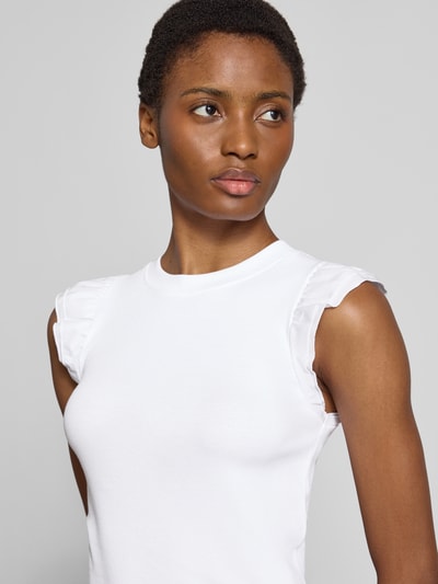 Frauenmodel trägt Slim Fit T-Shirt aus Baumwoll-Mix von Rich & Royal, weiß, Rundhalsausschnitt, Rüschenbesatz, Nahaufnahme Oberkörper.