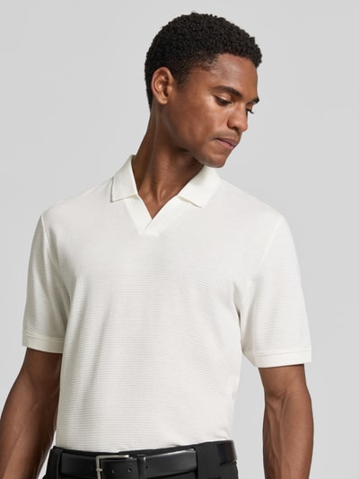Männermodel trägt Regular Fit Poloshirt aus Baumwoll-Mix von s.Oliver RED LABEL in Weiß, feine Struktur, Nahaufnahme Oberkörper.