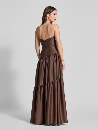 Vrouwenmodel draagt Regular Fit Avondjurk in plooien-look van Luxuar, satijn, getailleerde pasvorm, A-lijn, naadritssluiting, ruglengte 125 cm, borstwijdte 41 cm, strapless design, effen bruin, volle lichaamsweergave achteraan.