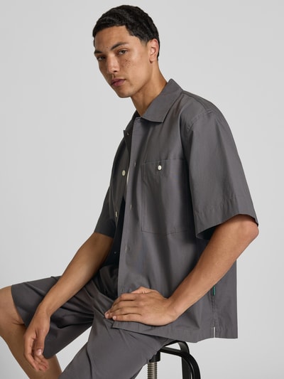 Männermodel trägt Relaxed Fit Freizeithemd mit Kentkragen von ANNARR in Grau, Reine Baumwolle, Brusttasche, Kurzärmelig, Nahaufnahme Oberkörper.