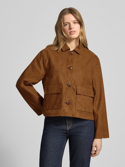 Modelka nosi Regular Fit Blousonjacke in Veloursleder-Optik od Review, brązowa, z kołnierzem, kieszeniami i zapięciem na guziki, krótka kurtka, długość tyłu 58 cm, szerokość ramion 39 cm, szerokość w rozmiarze S 53 cm, długość rękawa 58 cm, zdjęcie całej sylwetki z przodu.