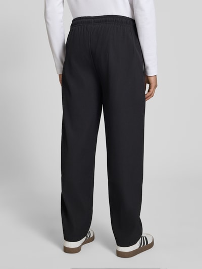 Männermodel trägt Sweatpants mit Strukturmuster und elastischem Bund von Pegador, Material-Mix mit Stretch-Anteil, Relaxed-Fit, Ganzkörperansicht Rückansicht.