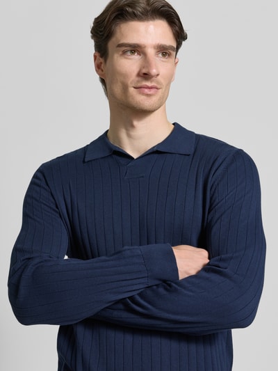 Männermodel trägt dunkelblaues Loose Fit Poloshirt aus reiner Baumwolle Modell 'TORINO' von SELECTED HOMME, Rippstruktur, Nahaufnahme Oberkörper.