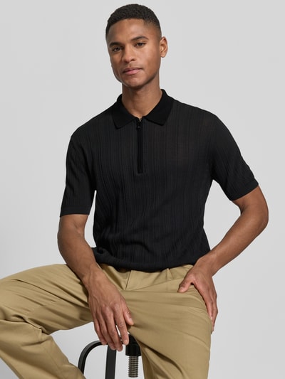 Männermodel trägt Body Fit Poloshirt mit kurzem Reißverschluss von Emporio Armani aus reiner Baumwolle, Polokragen, gerippte Abschlüsse, schwarze Farbe, strukturierte Textur, Rückenlänge bei Größe M: 66 cm, Nahaufnahme Oberkörper.