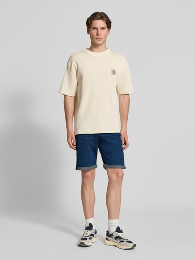 Männermodel trägt Jeansshorts mit Umschlag Modell 'RICK' von Jack & Jones im Regular-Fit aus Baumwoll-Mix mit Woll-Anteil, Eingrifftaschen, Bundweite 42 cm, Innenbeinlänge 21 cm, Ganzkörperansicht von vorne.
