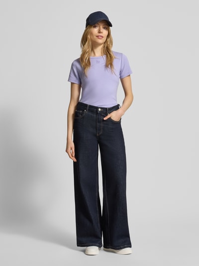 Vrouwenmodel draagt Slim Fit T-Shirt aus Baumwoll-Mix Modell 'DELORIS' van HUGO in effen lichtpaars, korte mouw, fijnrib, labeldetail, ronde hals, Ganzkörperansicht van voren.