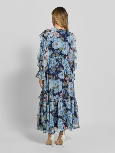 Vrouwenmodel draagt Maxikleid met Rüschen und Knopfleiste van Oui in blauw met bloemenprint, getailleerd model, V-hals, mouwen met ruches, knoopsluiting, volantzoom, ruglengte maat 36: 135 cm, borstwijdte maat 36: 39 cm, mouwlengte maat 36: 59 cm, geheel van achteren gezien