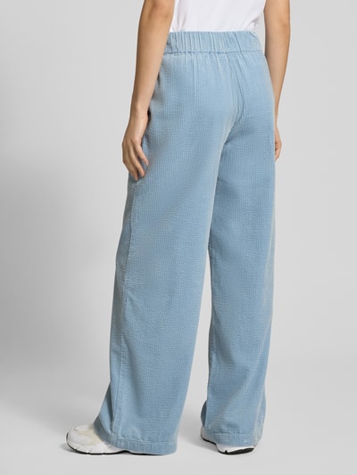 Frauenmodel trägt Relaxed Fit Cordhose aus reiner Baumwolle von Marc O'Polo Denim in Optik: Unifarben, Struktur, Label-Stitching-Applikation, elastischer Bund, seitliche Eingrifftaschen, Cord, Ganzkörperansicht Rückansicht.