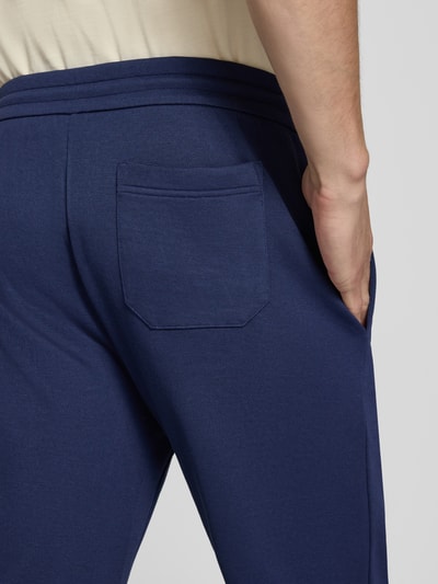 Männermodel trägt Loose Fit Sweathose mit Logo-Stitching Modell 'MESH FACE' von Polo Ralph Lauren, dunkelblau, Nahaufnahme Hüfte, Herren Sweathose von Polo Ralph Lauren.