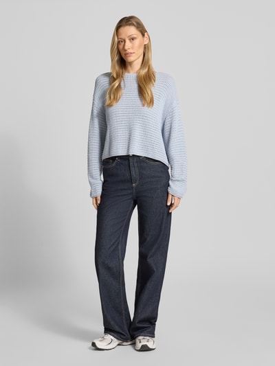 Vrouwenmodel draagt Pullover met überschnittenen Schultern Modell 'IMENIA' van Drykorn van pure katoen in lichtblauw met losser fit, grof gebreid met gaatjespatroon, ronde hals en wijde schouders, lengte rug bij maat S 48 cm, mouwlengte 58 cm, frontaal volledig beeld.