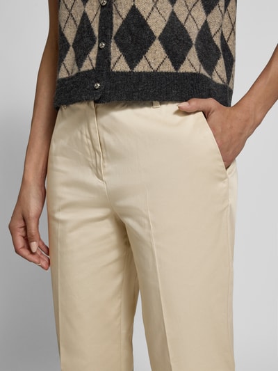 Kobiece modelka nosi Slim Fit Chino aus Baumwoll-Satin od s.Oliver BLACK LABEL, jasny beż, bawełniany satynowy materiał, detaliczne zbliżenie na górną część spodni.
