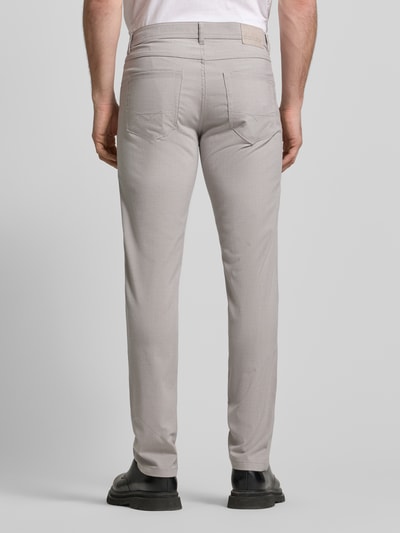 Männermodel trägt Chino mit 5-Pocket-Design von Christian Berg Men in hellem Beige, gerader Schnitt, Material-Mix, Ganzkörperansicht Rückansicht.