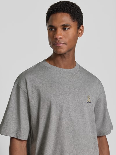 Męski model nosi szarą koszulkę krój oversized Relaxe Fit Oversized Shirt aus reiner Baumwolle Modell 'ICONIC Å MAARKOS' von ARMEDANGELS, Herren Oversized Shirt, zbliżenie na górną część ciała.
