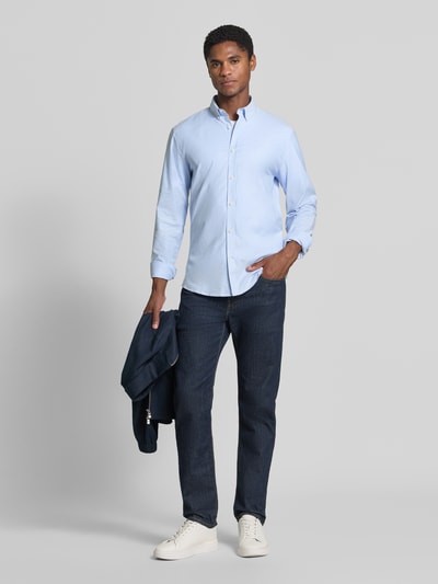 Männermodel trägt Regular Fit Freizeithemd aus Baumwoll-Mix Modell 'Oxford' von Lindbergh in Hellblau, glatte Struktur, Ganzkörperansicht von vorne. Kontext: Baumwoll-Elasthan-Mix, Button-Down-Kragen, 1-Knopf-Manschetten, abgerundeter Saum, Rückenlänge 77 cm, Schulterbreite 44 cm, Ärmellänge 66 cm.