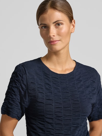 Frauenmodel trägt Slim Fit T-Shirt aus Viskose-Mix Modell 'NATACHA' von Cph Muse, dunkelblau mit Strukturmuster, Nahaufnahme Oberkörper. Damen T-Shirt, Rückenlänge 47 cm, Ärmellänge 24 cm.