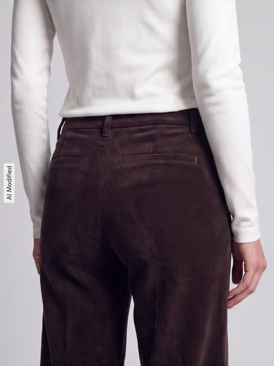 Frauenmodel trägt Regular Fit Cordhose mit angedeuteten Taschen Modell 'AMELIE' von CAMBIO, braun, feine Cordstruktur, Nahaufnahme Rückansicht, KI-modifiziertes Bild.
