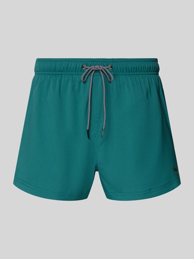 Produktfoto, Badehose mit Seitentaschen und Klettverschlusstasche hinten von PUMA in Türkis, Regular-Fit, elastischer Bund, glatte Oberfläche.