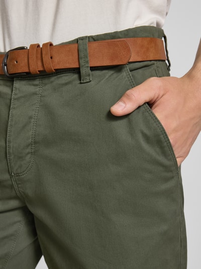 Männermodel trägt Shorts mit Gürtel Modell 'MIKE' von Redefined Rebel in Olivgrün, Baumwollstruktur, Eingrifftaschen, Nahaufnahme Hüfte, Regular Fit.