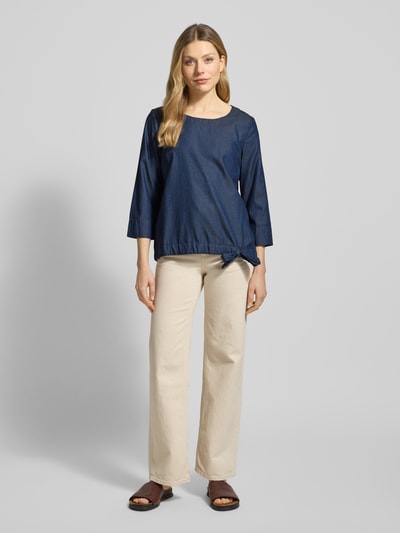 Modelka nosi Blusenshirt im Denim-Look mit 3/4-Arm von Christian Berg Woman, mieszanka lyocellu i bawełny, krój regular fit, imitacja denimu, okrągły dekolt, rękaw o dł. 3/4, długość tyłu w rozmiarze 36: 63 cm, długość rękawa w rozmiarze 36: 48 cm, ciemnoniebieski, gładka faktura, całkowity widok z przodu.