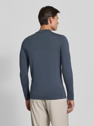 Männermodel trägt DRYKORN Slim Fit Longsleeve aus reiner Schurwolle Modell 'Arwon' in Dunkelblau, strukturierte Textur, Ganzkörperansicht Rückansicht.