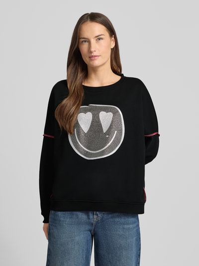Modelka kobieca nosi czarne Sweatshirt mit Label-Detail od miss goodlife z bawełny, luźny krój, ściągacze, okrągły dekolt, widok z przodu.