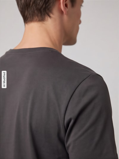 Männermodel trägt T-Shirt mit Rundhalsausschnitt von Christian Berg Men, glatte Oberfläche, dunkles Grau, Detailaufnahme Rückansicht, KI-modifiziertes Bild
