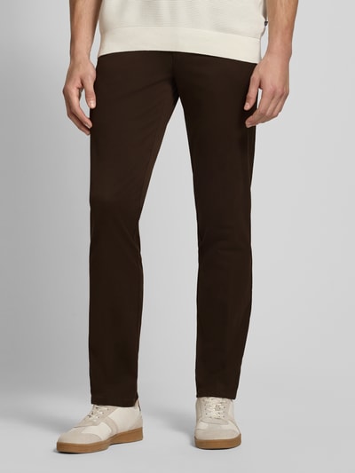 Männermodel trägt dunkelbraune Regular Fit Chino aus Baumwoll-Mix Modell 'Lupus' von MMX, glatte Struktur, Nahaufnahme Oberkörper bis Schuhe. Herren Chino von MMX.