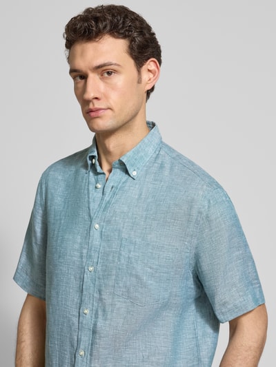 Męski model nosi Regular Fit Freizeithemd aus Leinen od Christian Berg Men, lekka niebieska tkanina, krótki rękaw, guziki, kieszeń na piersi, widok na górną część ciała z przodu.