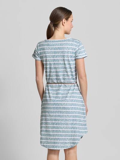 Frauenmodel trägt Knielanges T-Shirt-Kleid mit Bindegürtel von G.I.G.A. DX aus Reine Baumwolle mit Gerader-Schnitt, Knielänge, Rundhalsausschnitt, Knopfleiste, Bindegürtel, gestreiftem Muster in Weiß und Blau. Ganzkörperansicht Rückansicht.