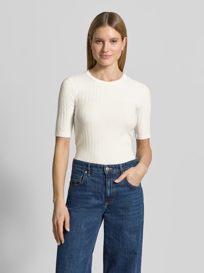 Modelka nosi damski t-shirt w kolorze ecru, efekt prążkowania, okrągły dekolt, krój slim fit, model 'Savka' od OPUS, mieszanka materiałów z dodatkiem streczu, rękaw o dł. 1/2, długość tyłu w rozmiarze 36: 56 cm, zdjęcie w całej sylwetce z przodu.