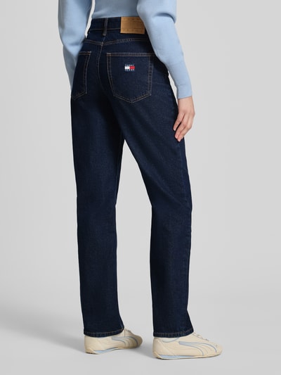 Frauenmodel trägt Slim Fit Straight Leg Jeans aus Baumwoll-Mix von Tommy Jeans in Optik: Unifarben mit Logo-Stitching, 5-Pocket-Design, Materialverarbeitung: Denim, Passform: Slim-Fit, High-Waist, Gesäßpasse, Knopf und verdeckte Knopfleiste, Rückansicht Ganzkörperansicht.