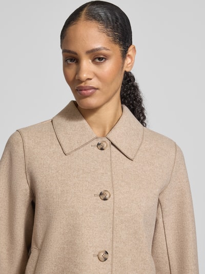 Frauenmodel trägt Jacke mit Umlegekragen Modell 'Juice' von Vila, beige, glatte Textur, Knopfleiste, Nahaufnahme Oberkörper.