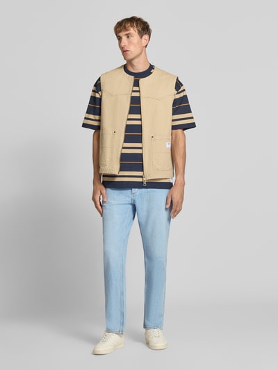 Männermodel trägt hellblaue Straight Fit Jeans aus Baumwoll-Mix Modell 'Jonah' von HUGO Blue, kombiniert mit gestreiftem Shirt, Ganzkörperansicht von vorne.