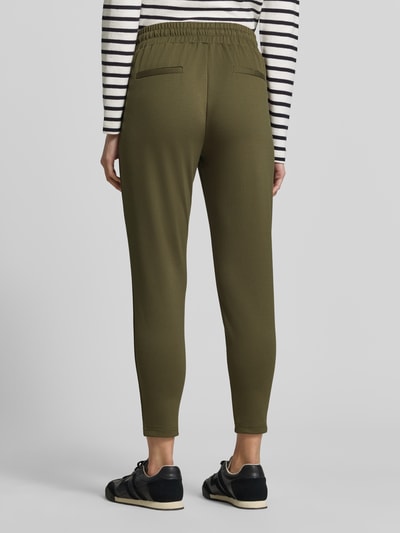 Frauenmodel trägt Sweatpants mit elastischem Bund Modell 'KATE' von ICHI in Olivgrün, verkürzte Passform, Detailaufnahme Rückansicht. Damen Sweatpants, Material-Mix mit Viskose-Anteil, elastischer Bund, Tunnelzug, Bundweite 37 cm, Innenbeinlänge 64 cm.