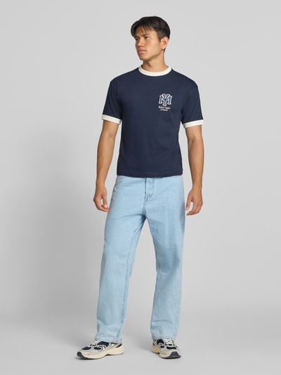 Męski model nosi Straight Fit Jeans aus reiner Baumwolle Modell 'Alex' von JACK & JONES, błękitny denim, 5 kieszeni, zapięcie na guzik i zamek błyskawiczny, szerokość w rozmiarze 32/32: 43 cm, długość wewnętrzna nogawki w rozmiarze 32/32: 77 cm, całkowity widok z przodu.