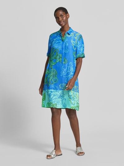 Vrouwenmodel draagt knielang Hemdblusenkleid aus Viskose van Betty Barclay, recht model, all-over look, verdekte knoopsluiting, zuiver viscose, ruglengte maat 36: 100 cm, borstwijdte maat 36: 44 cm, mouwlengte maat 36: 26 cm, overwegend blauw met groene en witte patronen, gladde textuur, Ganzkörperansicht van voren.