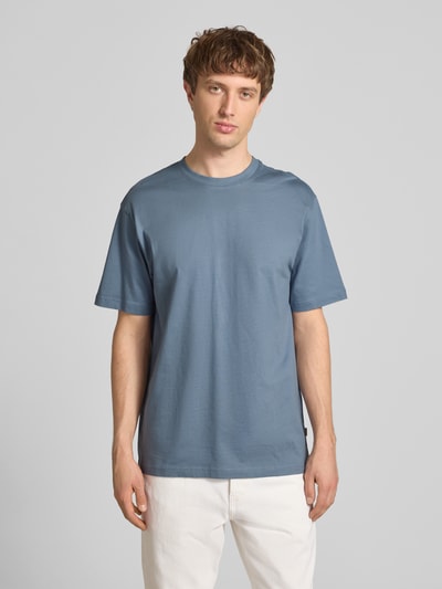 Männermodel trägt Relaxed Fit T-Shirt aus reiner Baumwolle Modell 'FRED LIFE' von Only & Sons, unifarben, Rundhals, Kurzarm, Ganzkörperansicht von vorne.