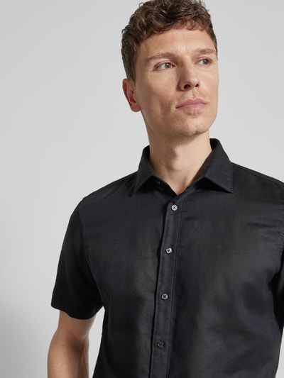 Männermodel trägt Slim Fit Freizeithemd aus Leinen-Mix von Jake*s in Schwarz, Kentkragen, kurzärmelig, Nahaufnahme Oberkörper.