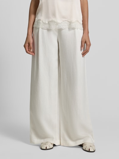 Frauenmodel trägt Stoffhose mit Gesäßtaschen von Jake*s Collection, Lockere Schnittform, Bundfalten, weiße Farbe, Nahaufnahme Oberkörper