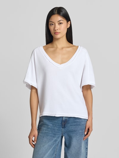 Frauenmodel trägt Sweatshirt mit 1/2-Arm von American Vintage, reine Baumwolle, gerade Form, tiefer V-Ausschnitt, kurzärmelig, weiß, Ganzkörperansicht von vorne.