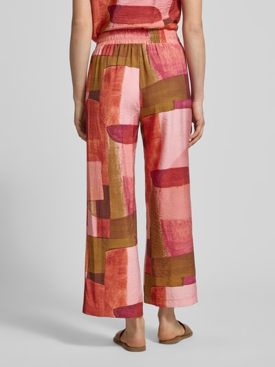 Frauenmodel trägt Stoffhose im Allover-Look Modell 'CATANIA' von Soyaconcept aus Viskose-Mix, Relaxed-Fit, bunte Muster, Ganzkörperansicht Rückansicht. Bundweite bei Größe S: 35 cm, Innenbeinlänge bei Größe S: 69 cm.